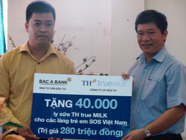 Tiếp nhận món quà từ Ngân hàng TMCP Bắc Á và Công ty CP sữa TH, ông Nguyễn Tiến Dũng - Phó Giám đốc Quốc gia các làng trẻ em SOS Việt Nam (phải) gửi lời cảm ơn sâu sắc đến các đơn vị tài trợ.